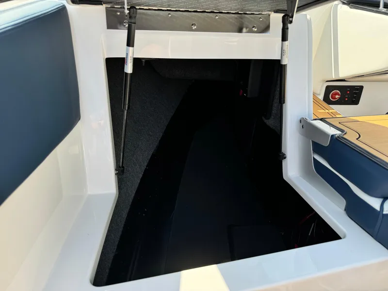 Slide: The Image of 2025 Nautique Ski 200 boat interior storage compartment with open hatch. - 19
