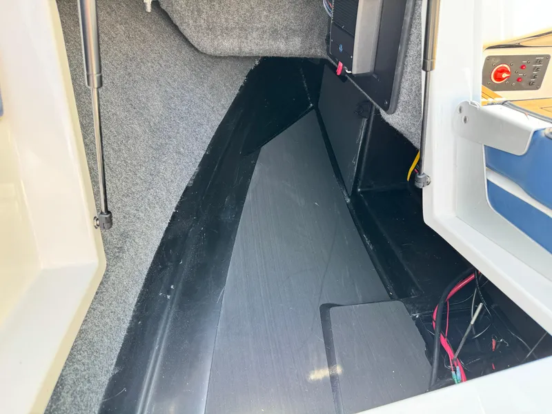 Slide: The Image of Interior storage compartment of 2025 Nautique Ski 200 boat, featuring carpeted and sleek design. - 20