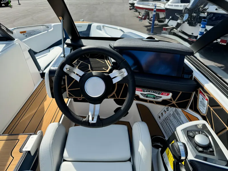 Slide: The Image of 2025 Nautique Ski 200 boat interior with steering wheel and dashboard controls. - 24