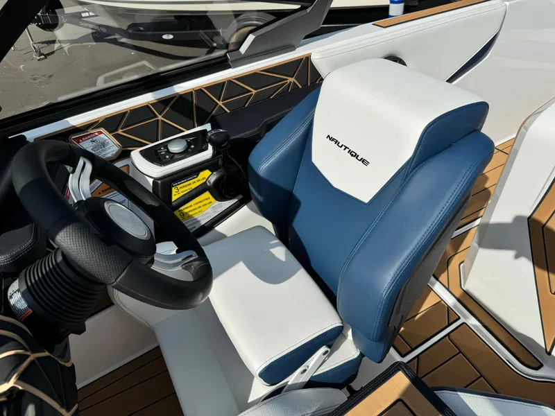 Slide: The Image of 2025 Nautique Ski 200 interior with blue and white seating, steering wheel, and control panel. - 31