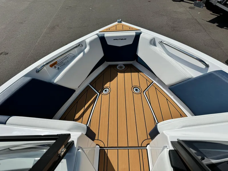 Slide: The Image of 2025 Nautique Ski 200 boat interior with teak flooring and cushioned seating. - 34