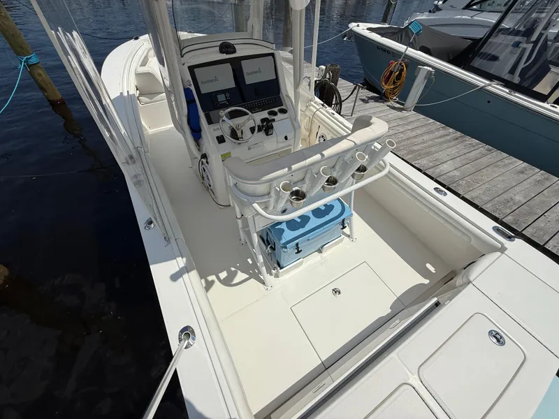 Slide: The Image of 2018 Regulator 23 boat interior with dual Garmin displays, docked by the water. - 10