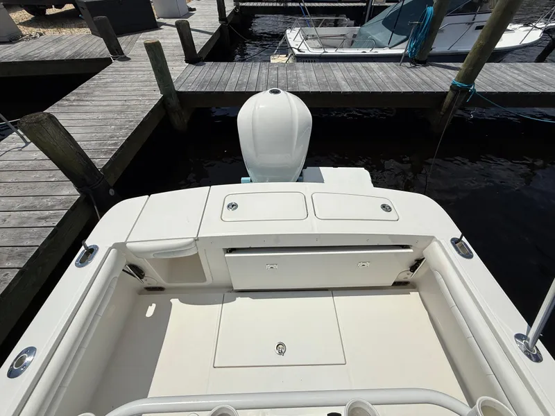 Slide: The Image of 2018 Regulator 23 boat stern view at dock, showcasing engine and deck layout. - 11