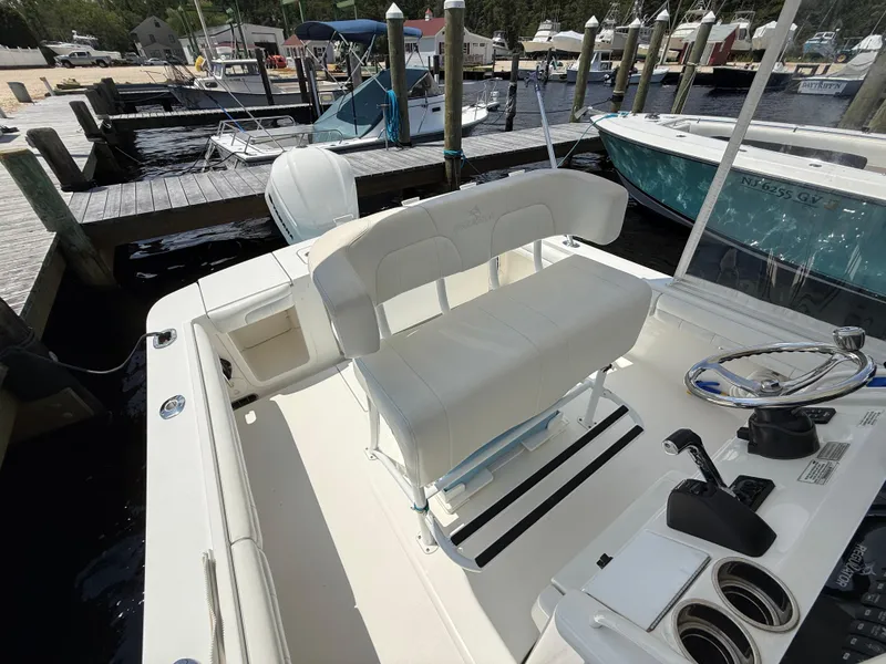 Slide: The Image of 2018 Regulator 23 boat interior at dock, featuring helm and seating area. - 14