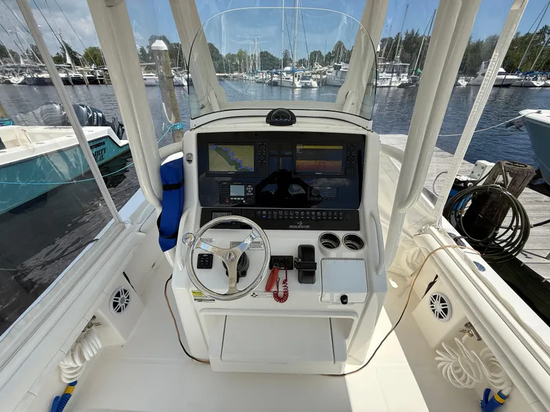 Slide: The Image of Cockpit view of a 2018 Regulator 23 boat with navigation equipment and steering wheel. - 15