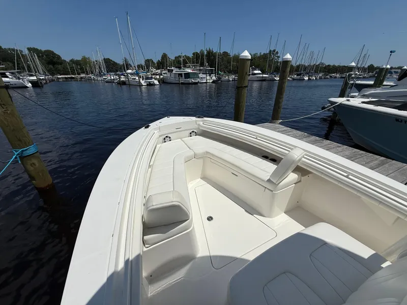 Slide: The Image of 2018 Regulator 23 boat docked at marina, featuring spacious seating and calm waters. - 21