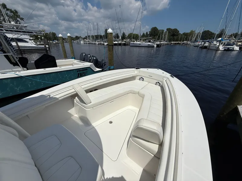 Slide: The Image of 2018 Regulator 23 boat docked in a marina, featuring spacious seating and clear skies. - 24