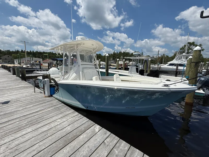 Slide: The Image of 2018 Regulator 23 boat docked at marina under partly cloudy sky. - 3
