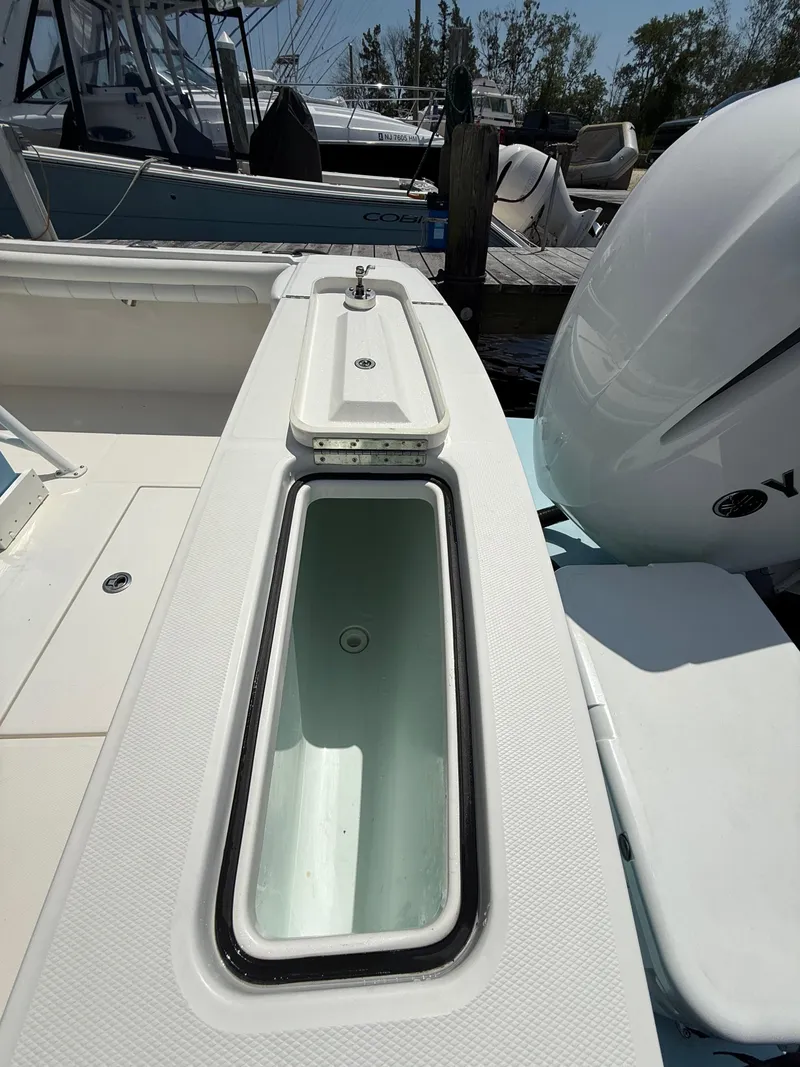 Slide: The Image of 2018 Regulator 23 boat with open storage compartment and Yamaha engine at dock. - 34