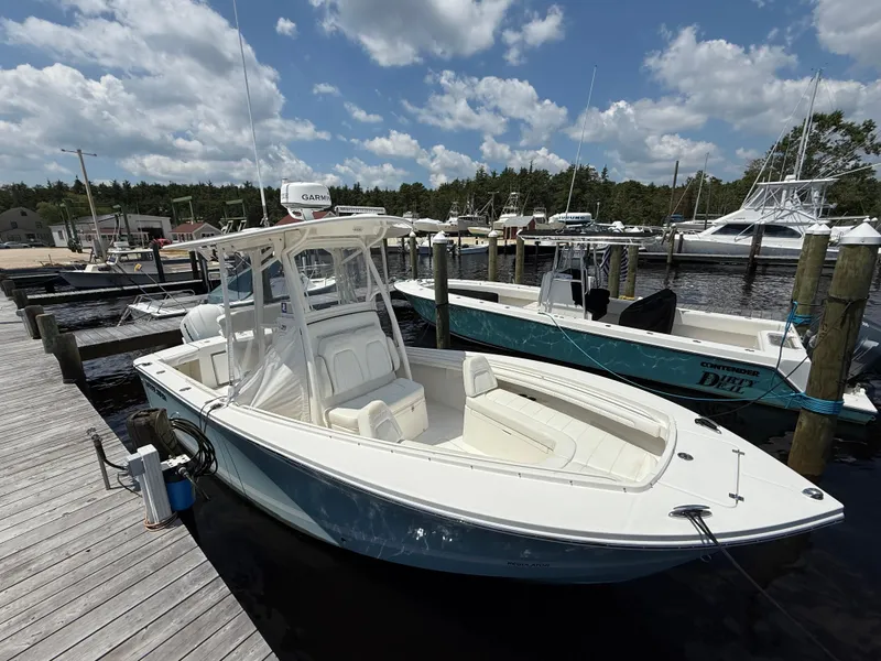 Slide: The Image of 2018 Regulator 23 boat docked at marina under partly cloudy sky. - 4