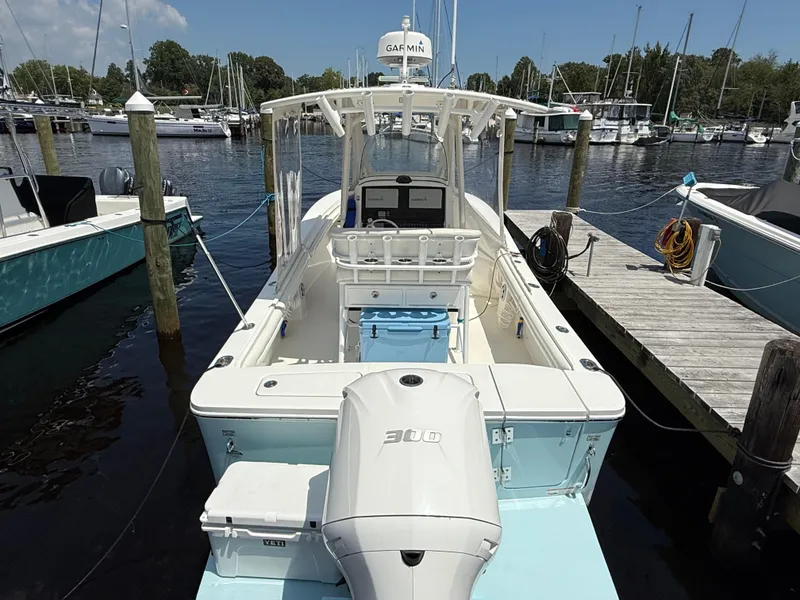 Slide: The Image of 2018 Regulator 23 boat docked at marina, featuring Garmin equipment and outboard motor. - 6
