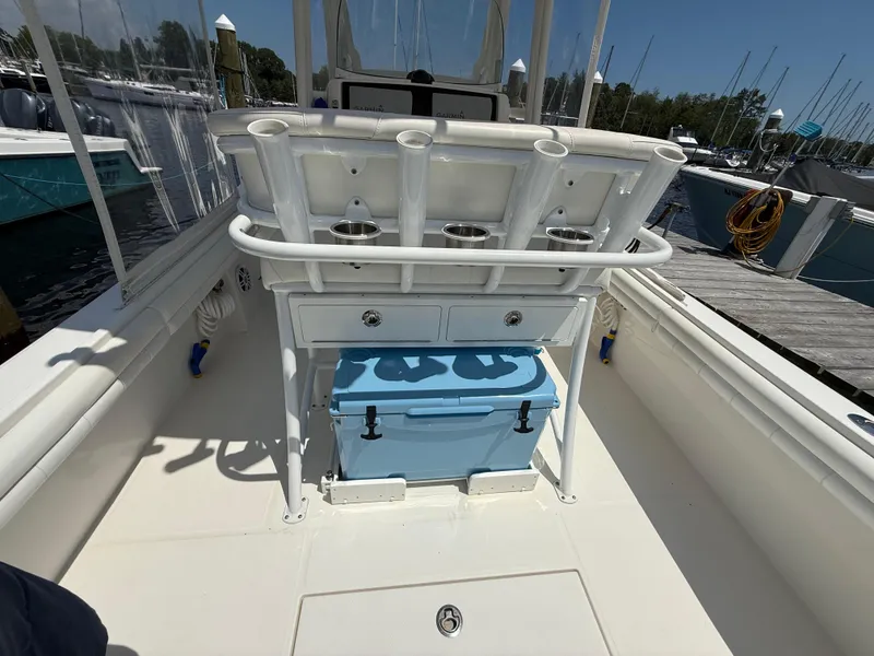 Slide: The Image of 2018 Regulator 23 boat interior with rod holders and blue cooler on deck. - 7