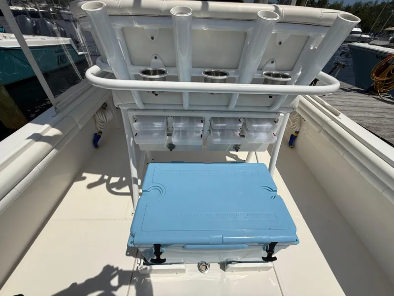 Slide: The Image of 2018 Regulator 23 boat interior with rod holders and blue cooler on deck. - 8