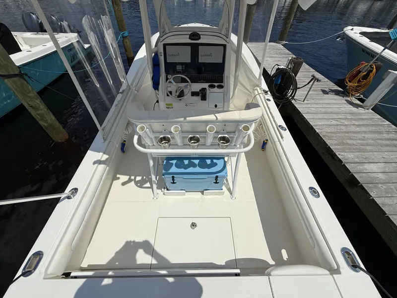 Slide: The Image of 2018 Regulator 23 boat interior with helm, docked by the water. - 9