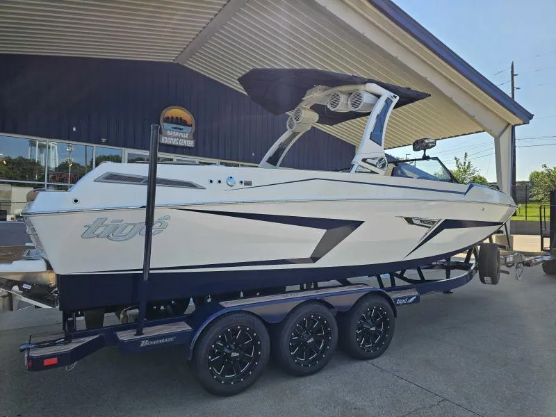 Slide: The Image of 2024 Tigé 24RZX boat on trailer at dealership, showcasing sleek design and modern features. - 2