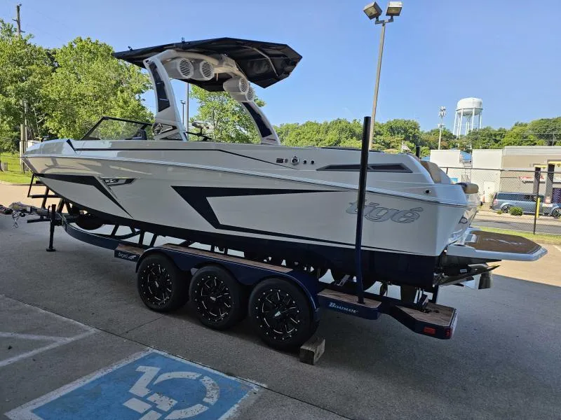 Slide: The Image of 2024 Tigé 24RZX boat on trailer, parked outdoors under clear sky. - 5