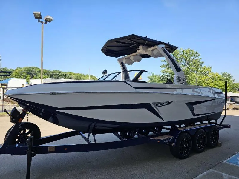 Slide: The Image of 2024 Tigé 24RZX boat on trailer, sleek design, parked outdoors under clear blue sky. - 6