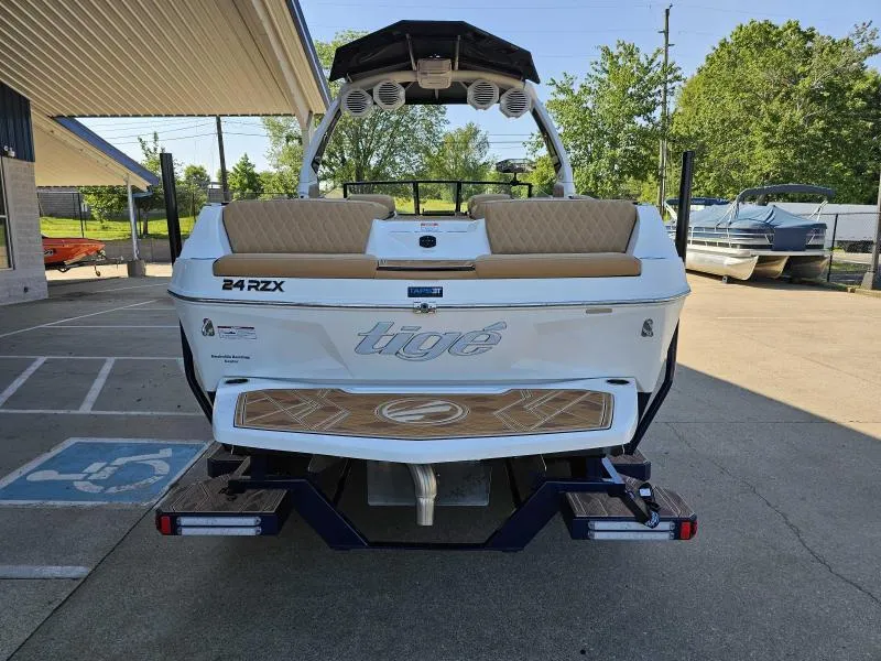 Slide: The Image of 2024 Tigé 24RZX boat rear view, parked outdoors, showcasing sleek design and seating. - 7