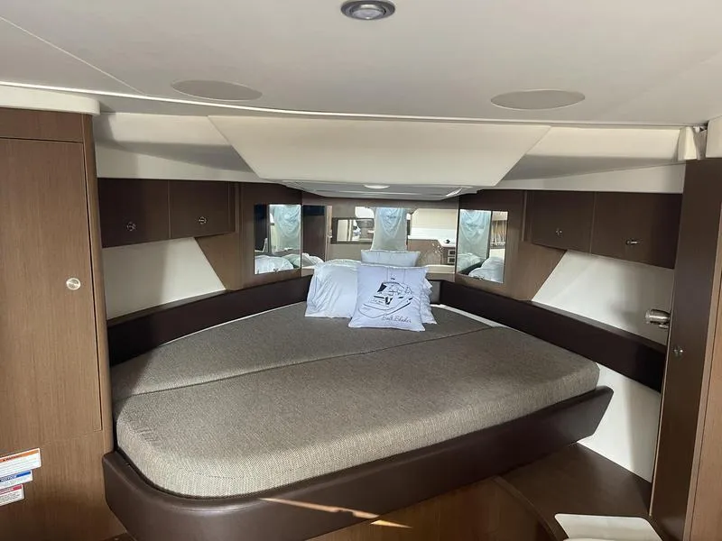 Slide: The Image of 2019 Sea Ray 350 Sundancer Coupe cabin with cozy bed and wooden cabinetry. - 15