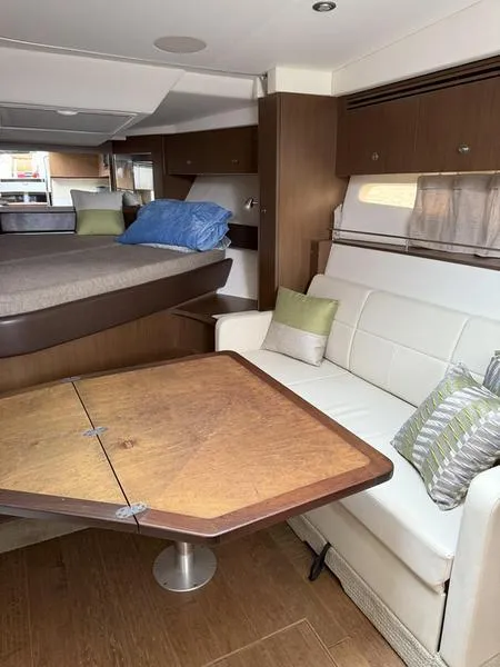 Slide: The Image of Interior of 2019 Sea Ray 350 Sundancer Coupe with cozy seating and wooden table. - 16