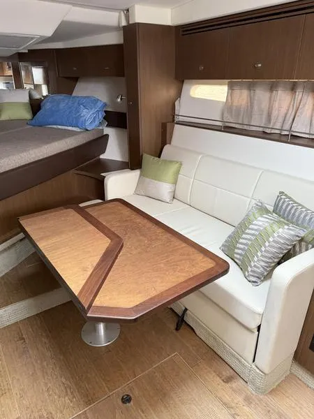 Slide: The Image of Interior of 2019 Sea Ray 350 Sundancer Coupe with sofa, table, and bed. - 24