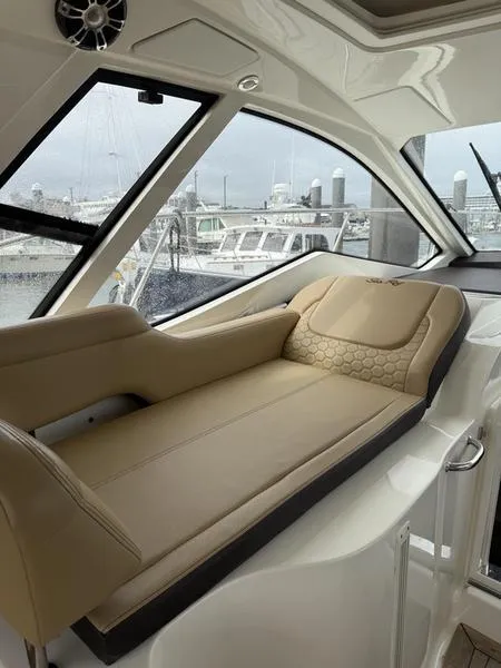 Slide: The Image of Luxurious interior of 2019 Sea Ray 350 Sundancer Coupe with beige seating and marina view. - 30