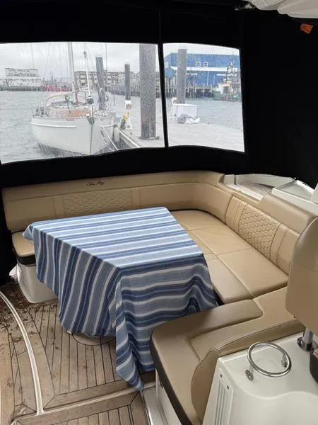Slide: The Image of 2019 Sea Ray 350 Sundancer Coupe interior with striped tablecloth and beige seating. - 35