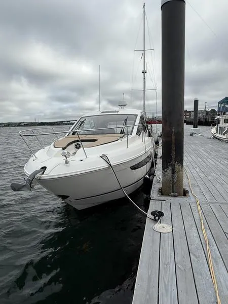 Slide: The Image of 2019 Sea Ray 350 Sundancer Coupe docked at a marina under cloudy skies. - 8