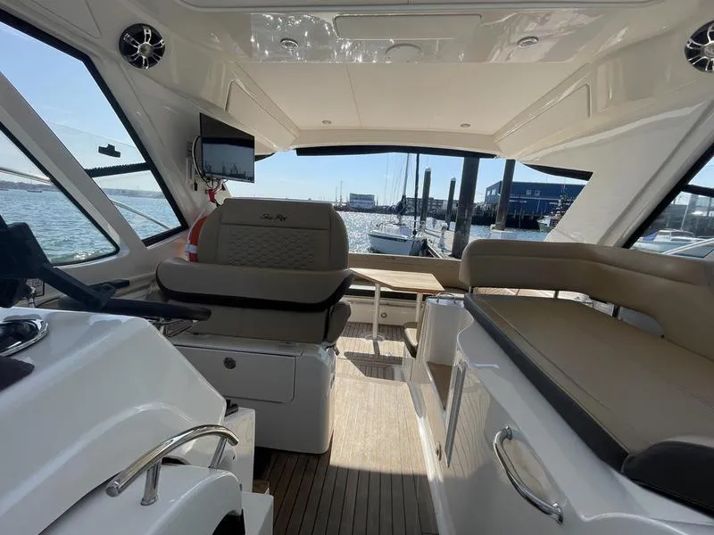 Slide: The Image of Interior view of 2019 Sea Ray 350 Sundancer Coupe yacht with seating and helm. - 9