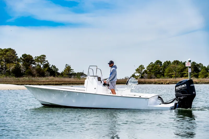 Slide: The Image of 1972 SeaCraft 20 Classic boat on water, man steering, Suzuki outboard motor, scenic background. - 0