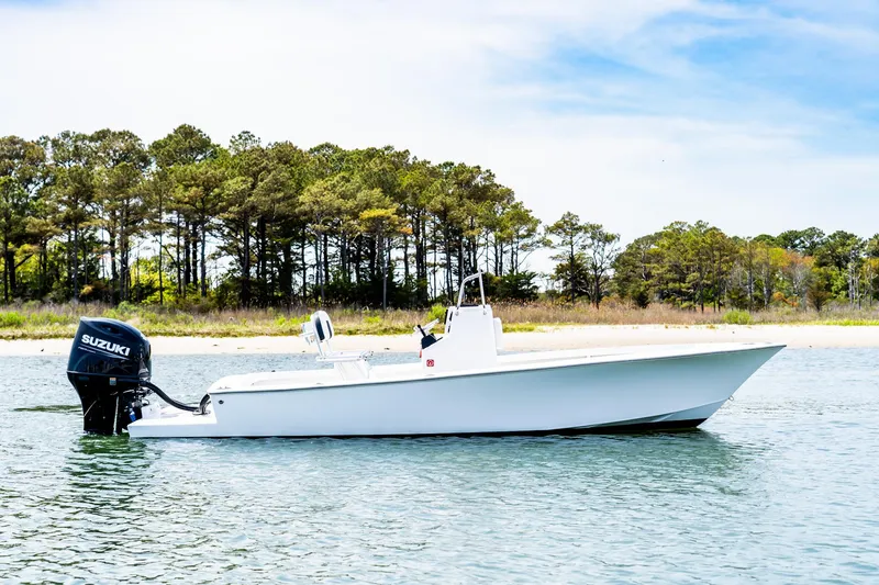Slide: The Image of 1972 SeaCraft 20 Classic boat with Suzuki motor on calm water near a wooded shoreline. - 1