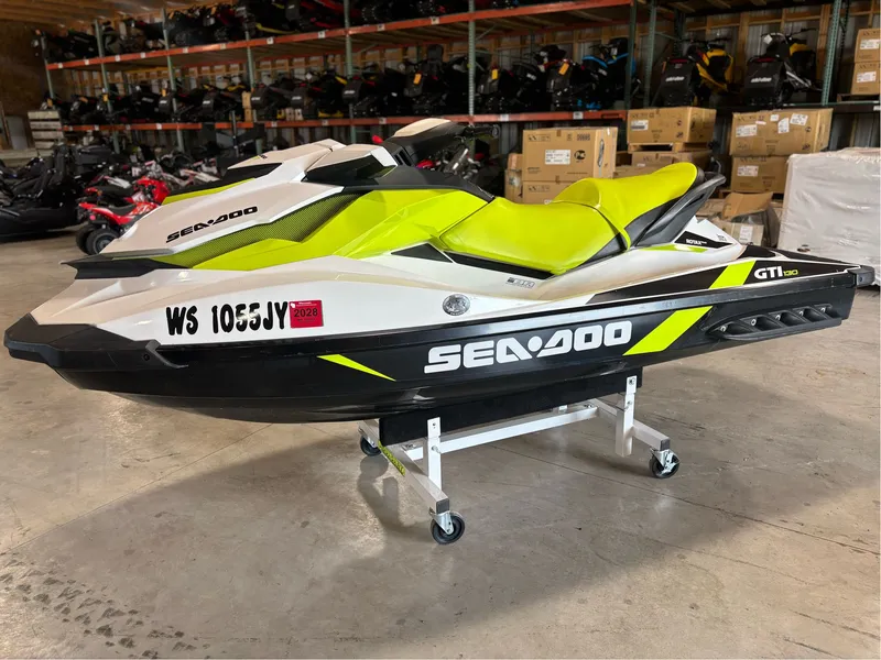 Slide: The Image of 2016 Sea-Doo GTI 130 jet ski with vibrant yellow seat in a storage facility. - 1