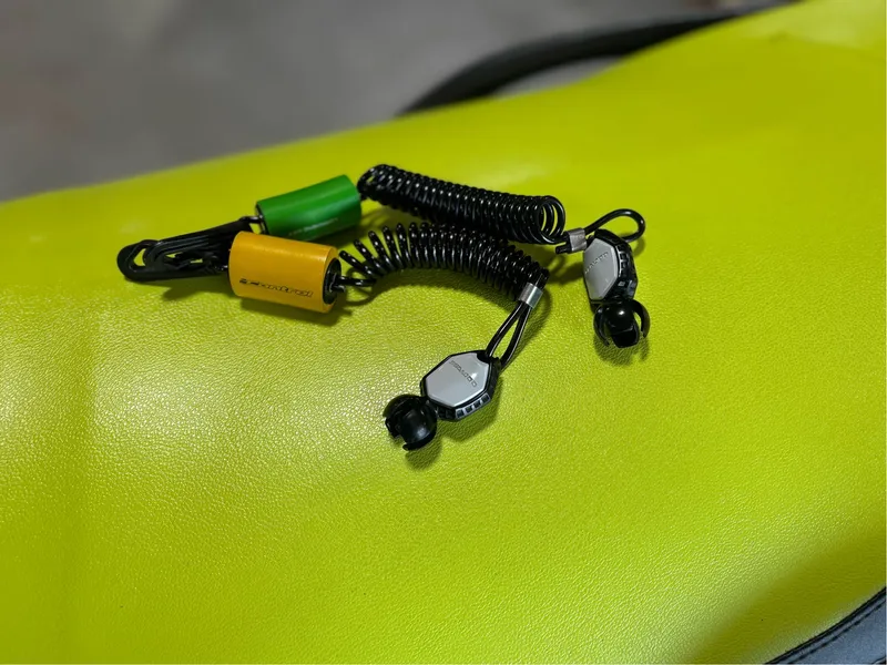 Slide: The Image of Coiled safety lanyard on a 2016 Sea-Doo GTI 130, resting on a bright yellow seat. - 4