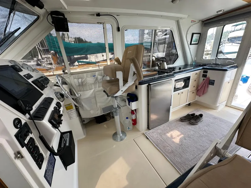 Slide: The Image of Interior of 2002 True North 38 boat with helm, kitchen, and seating area. - 11