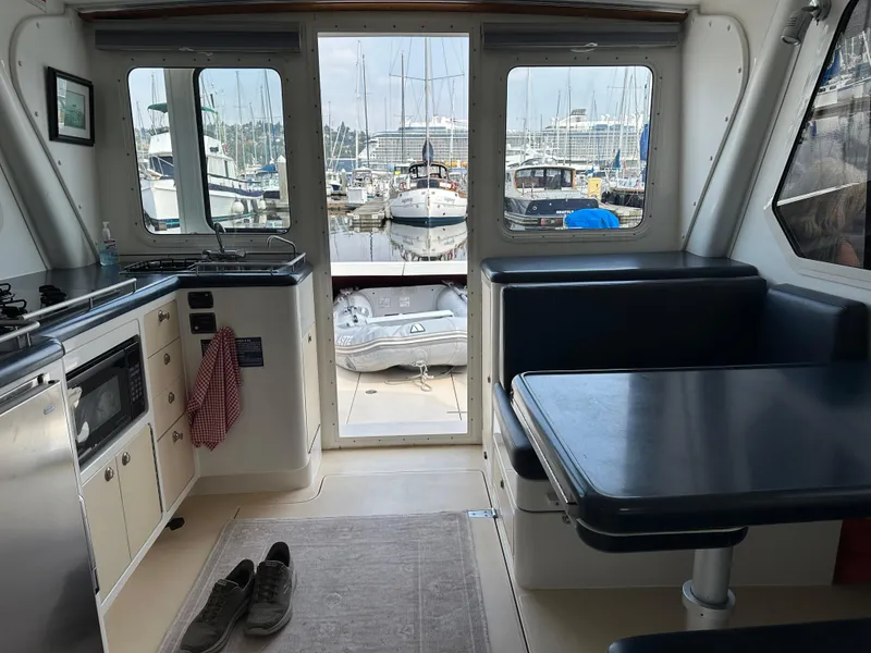 Slide: The Image of Interior of 2002 True North 38 yacht with kitchen and dining area, marina view. - 13