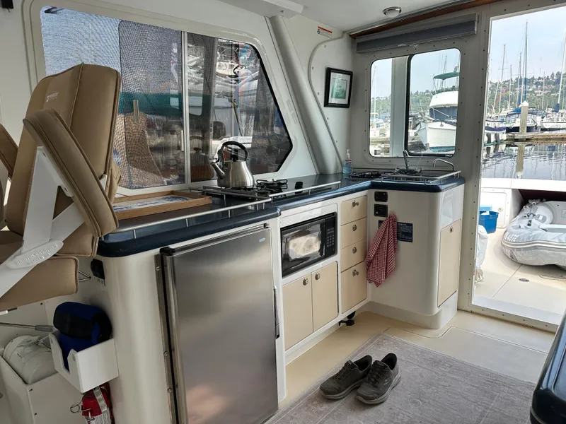 Slide: The Image of Interior of 2002 True North 38 boat with kitchenette, appliances, and marina view. - 14