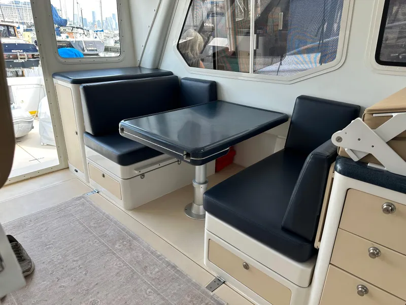 Slide: The Image of Interior of 2002 True North 38 boat with blue seating and table. - 15