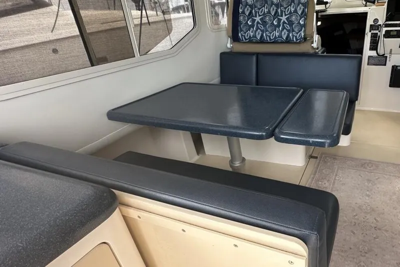 Slide: The Image of Interior of 2002 True North 38 boat with blue seating and table. - 18
