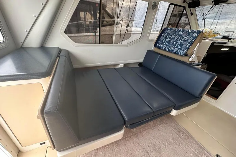Slide: The Image of Interior of 2002 True North 38 boat with blue cushioned seating and windows. - 20