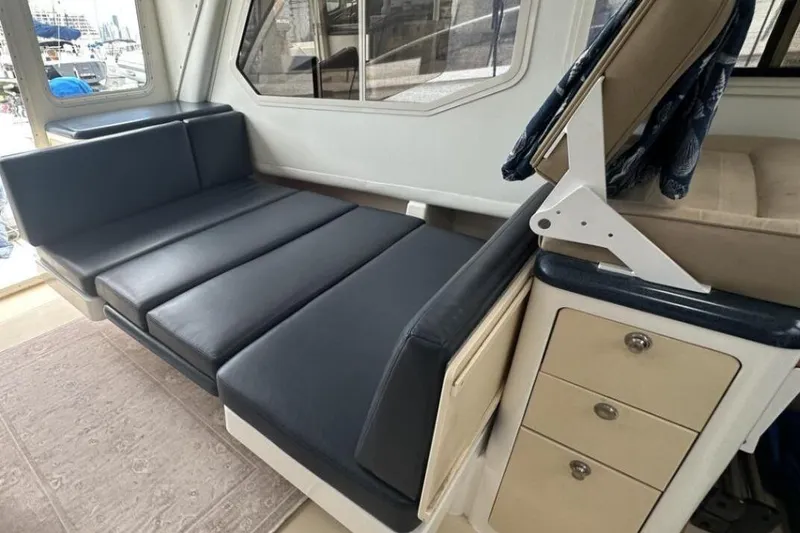 Slide: The Image of Interior of 2002 True North 38 boat with blue cushioned seating and storage drawers. - 21