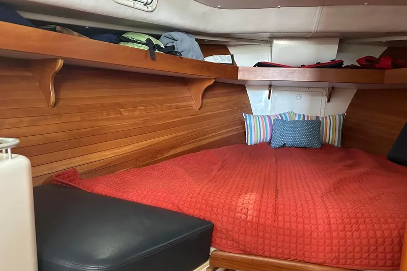 Slide: The Image of Cozy cabin interior of 2002 True North 38 boat with red bedding and wooden walls. - 22