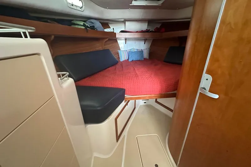 Slide: The Image of Cozy cabin interior of 2002 True North 38 boat with red bedding and wood accents. - 23
