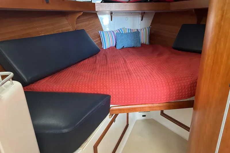 Slide: The Image of Cozy cabin interior of 2002 True North 38 boat with red bedding and cushions. - 24