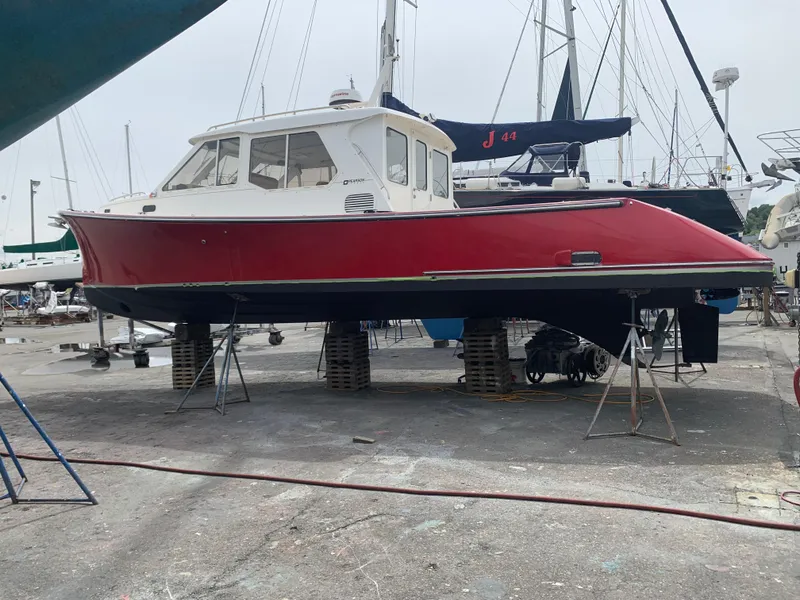 Slide: The Image of Red 2002 True North 38 boat on dry dock, surrounded by other vessels. - 29