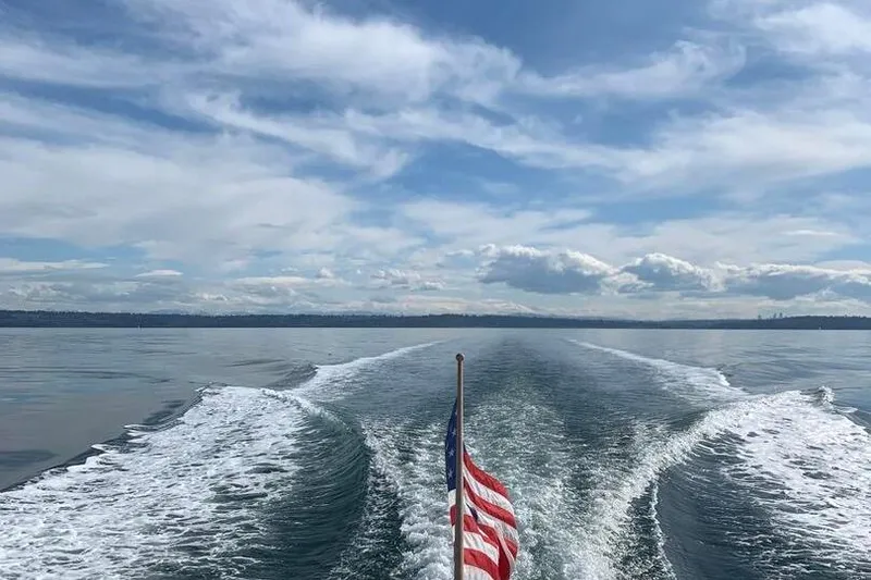 Slide: The Image of Wake of a 2002 True North 38 boat with American flag on open water. - 32