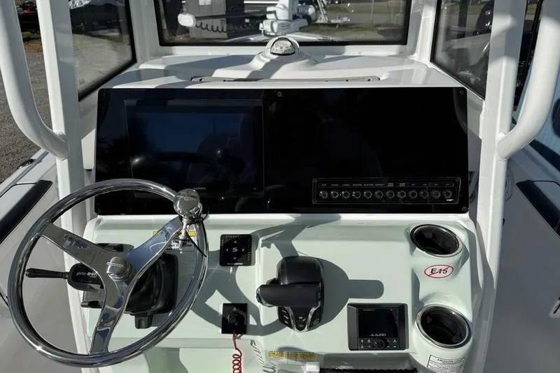 Slide: The Image of 2026 Tidewater 2300 Carolina Bay boat dashboard with steering wheel and control panel. - 24