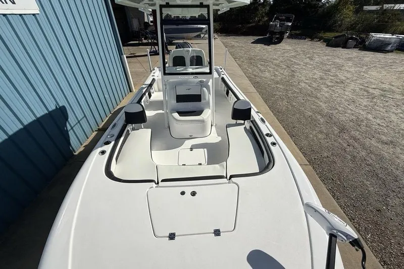 Slide: The Image of 2026 Tidewater 2300 Carolina Bay boat, white interior, parked near blue building. - 34