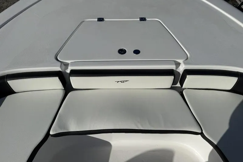 Slide: The Image of 2026 Tidewater 2300 Carolina Bay boat interior with cushioned seating and storage compartment. - 9