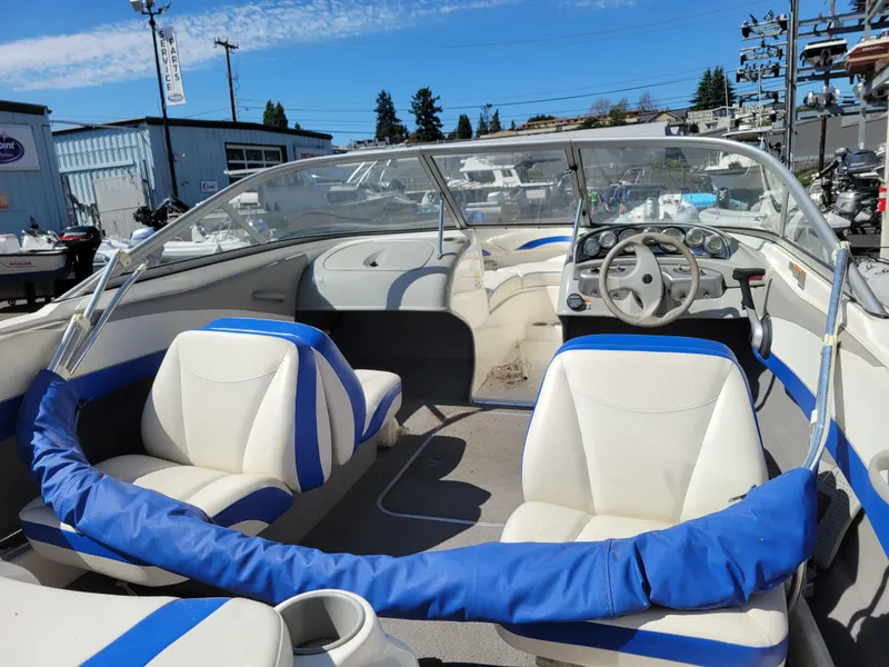 Slide: The Image of 2006 Bayliner 195 boat interior with blue and white seating, steering wheel, and dashboard. - 10