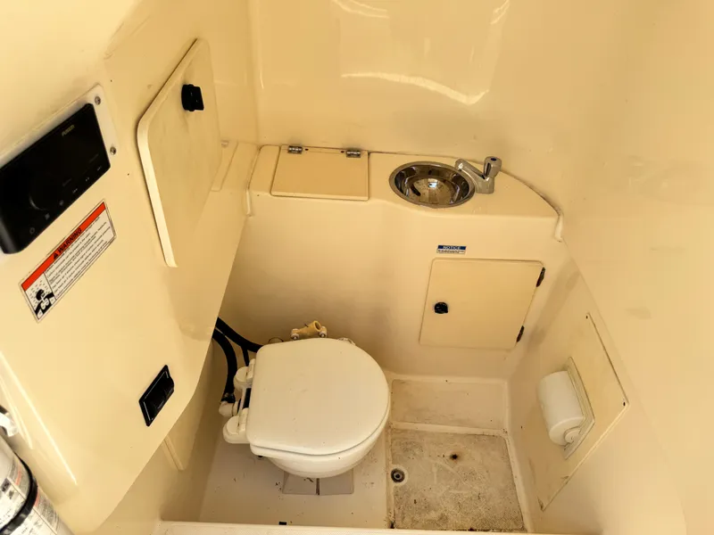 Slide: The Image of 2010 Pursuit C 280 Center Console boat interior with toilet and sink. - 19